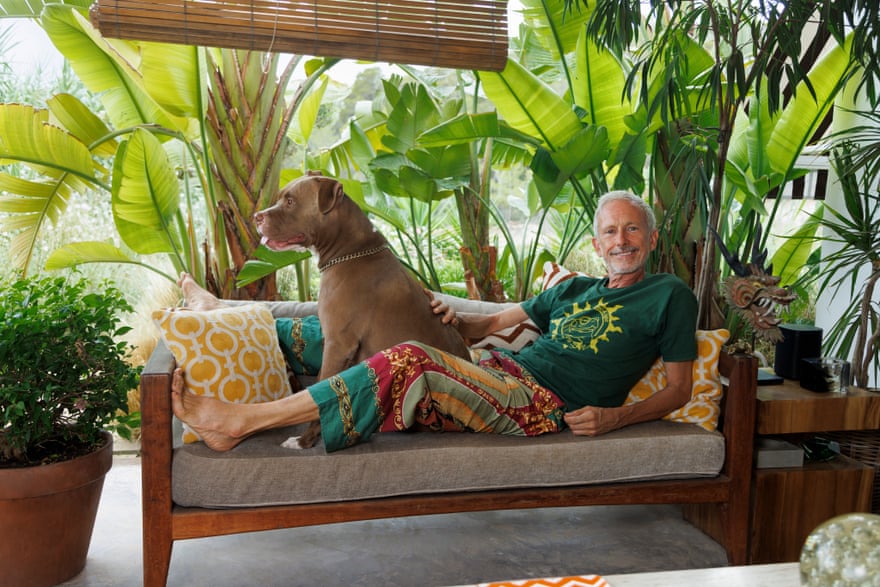 Patrick Cox relaxing on a sofa with his dog Titus outside his home in Ibiza