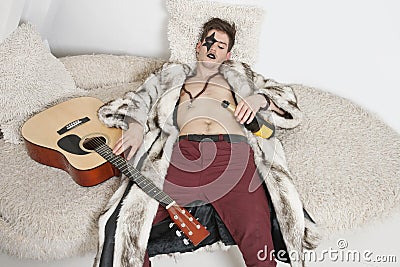 drunk-young-man-guitar-sleeping-sofa-30854448.jpg