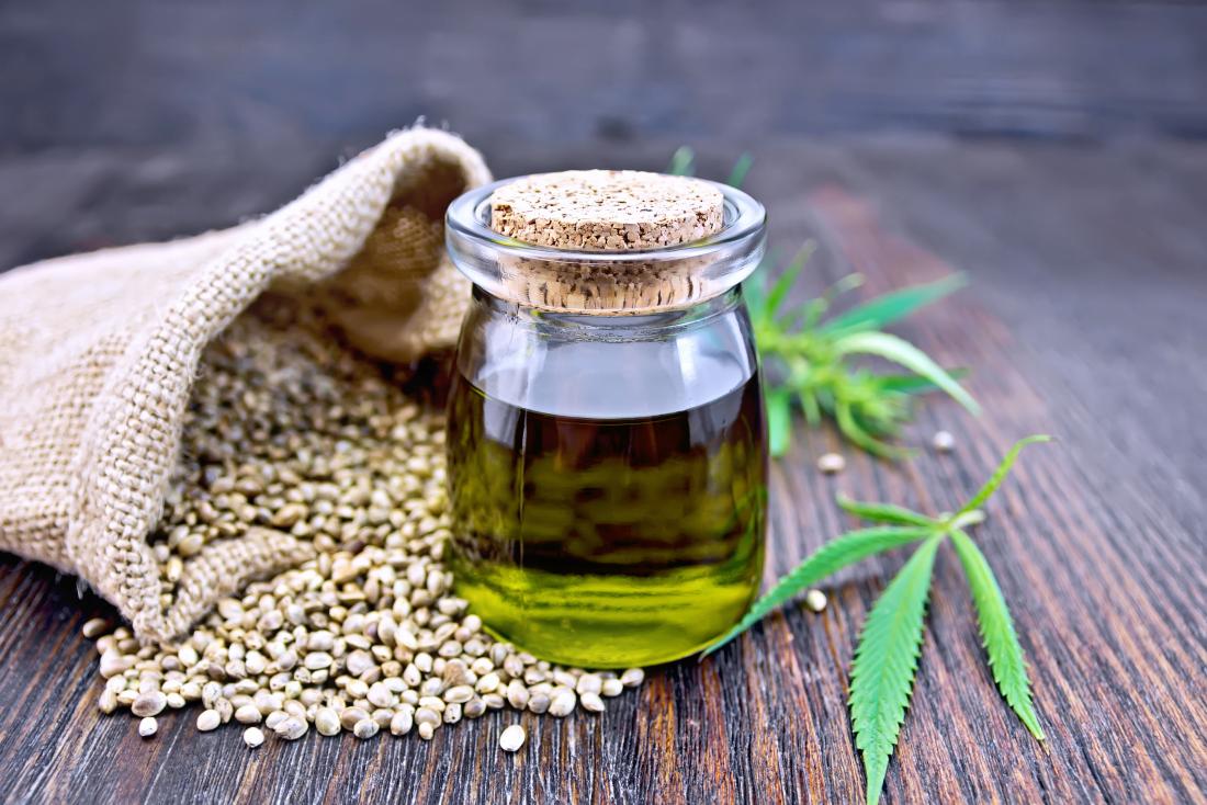 hemp-oil-in-glass-bottle-next-to-hemp-seeds-and-leaves-on-wooden-table.jpg