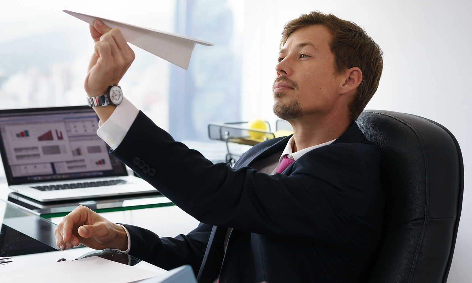 young-man-in-office-holds-paper-airplane.jpg